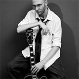 Kris of Everyday Neptune, seated with a guitar